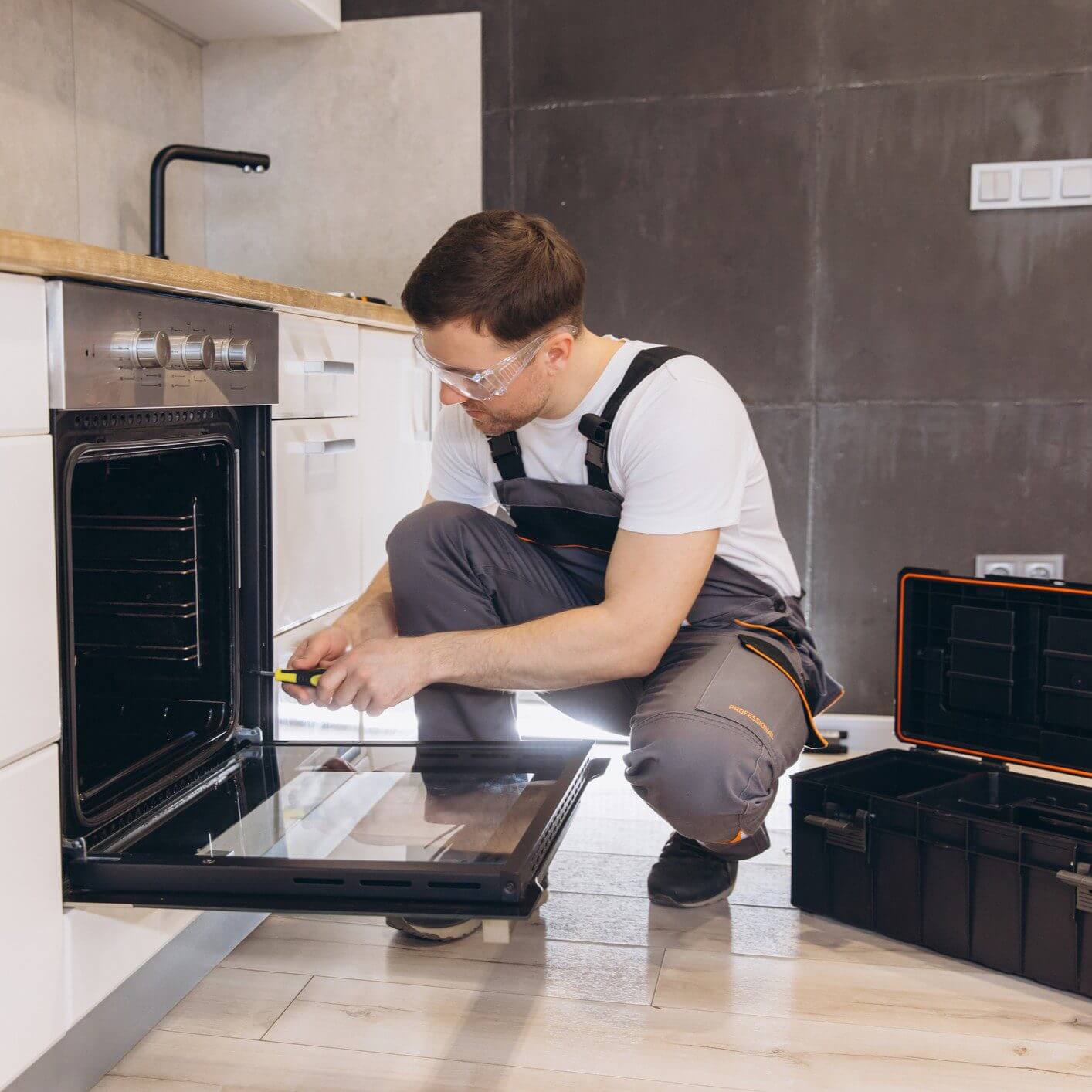 Man fixing oven in kitchen