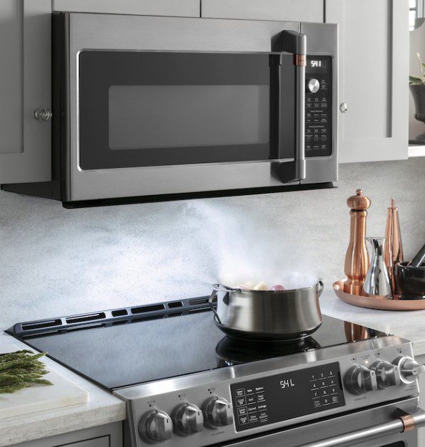 Steam rises from a pot on a modern stovetop in a kitchen.